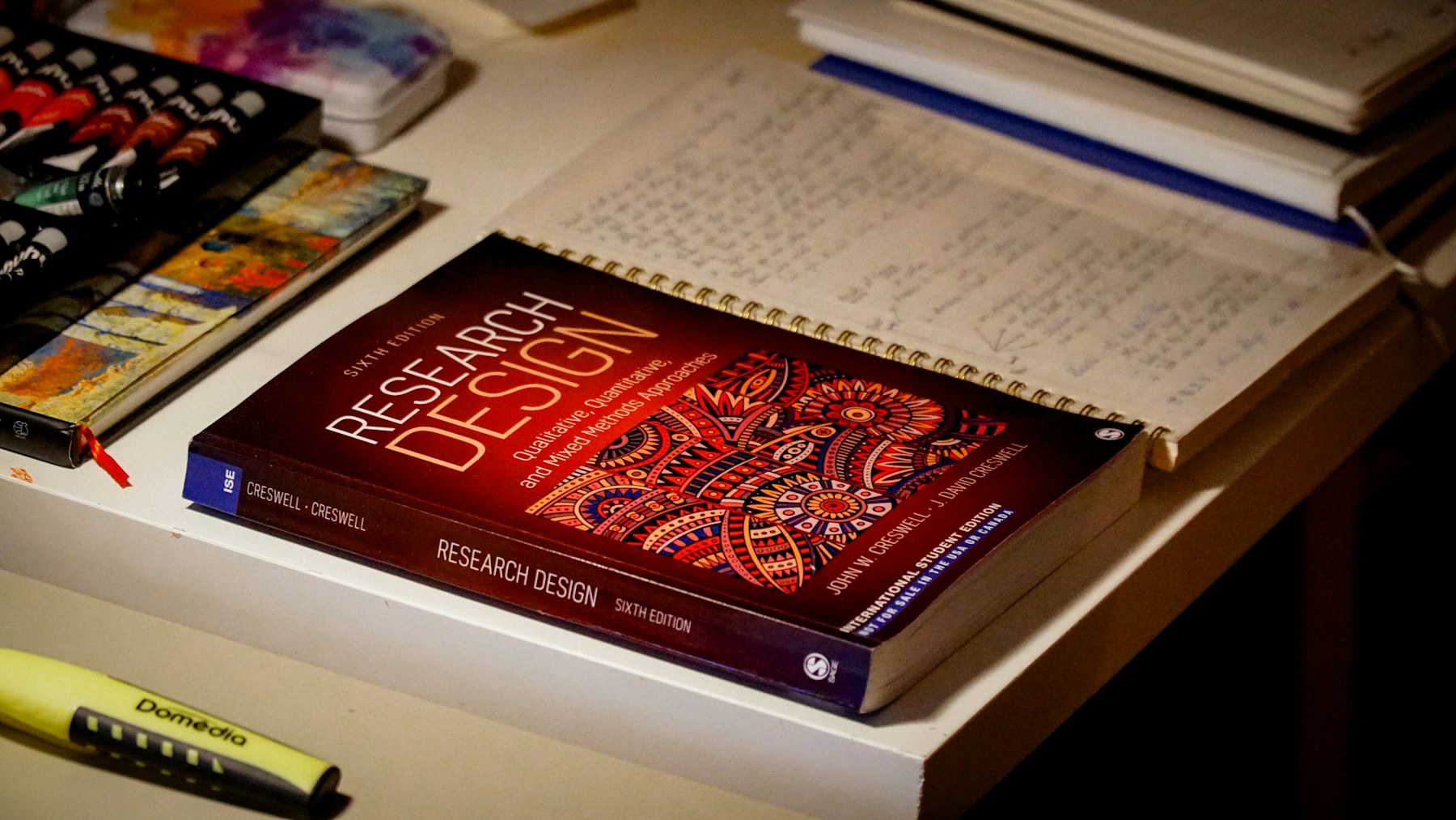 Professional research workspace with research-design book and notes